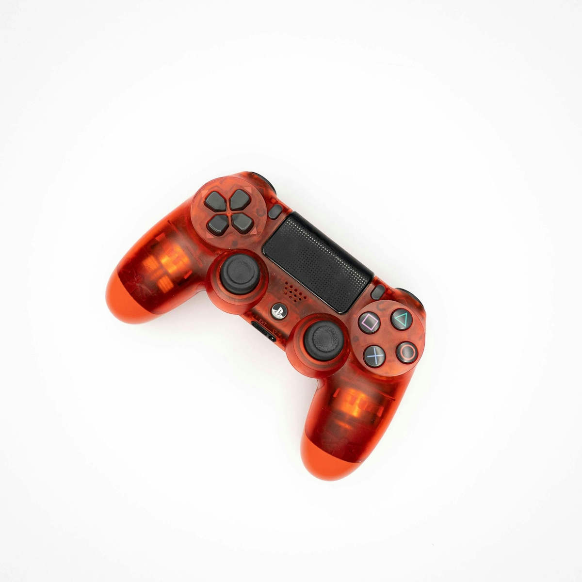 Top view of modern orange gamepad for game console placed on white background